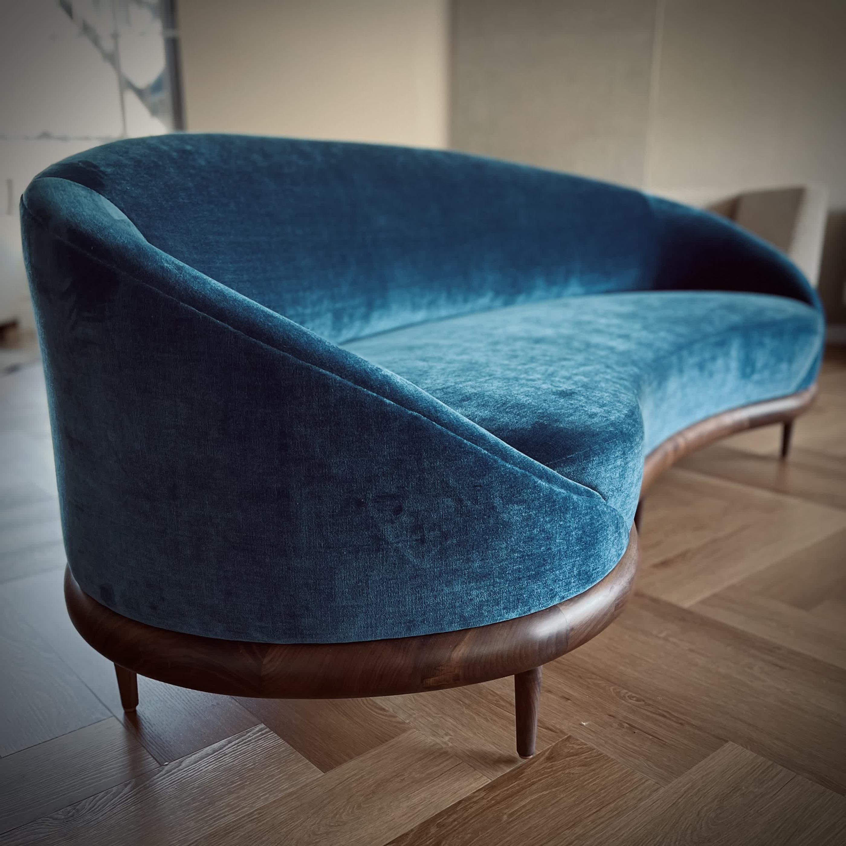 Finished curved blue velvet settee with walnut base