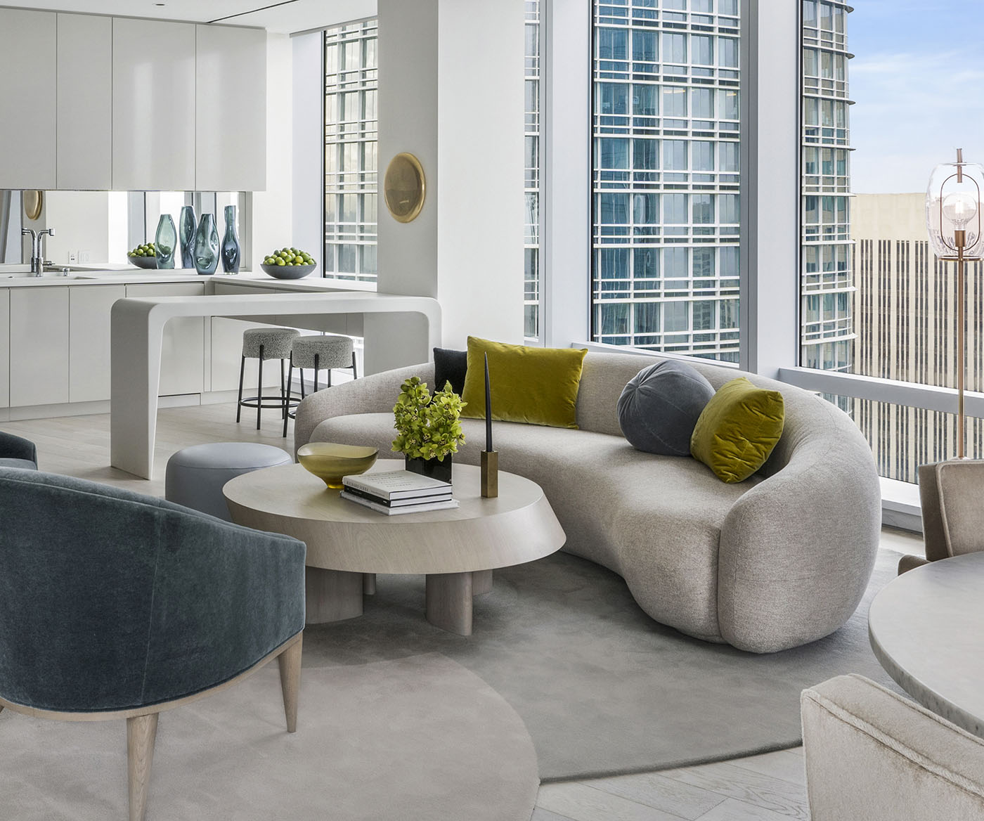 Finished curved sofa and upholstered chairs in a light-filled Fremont interior
